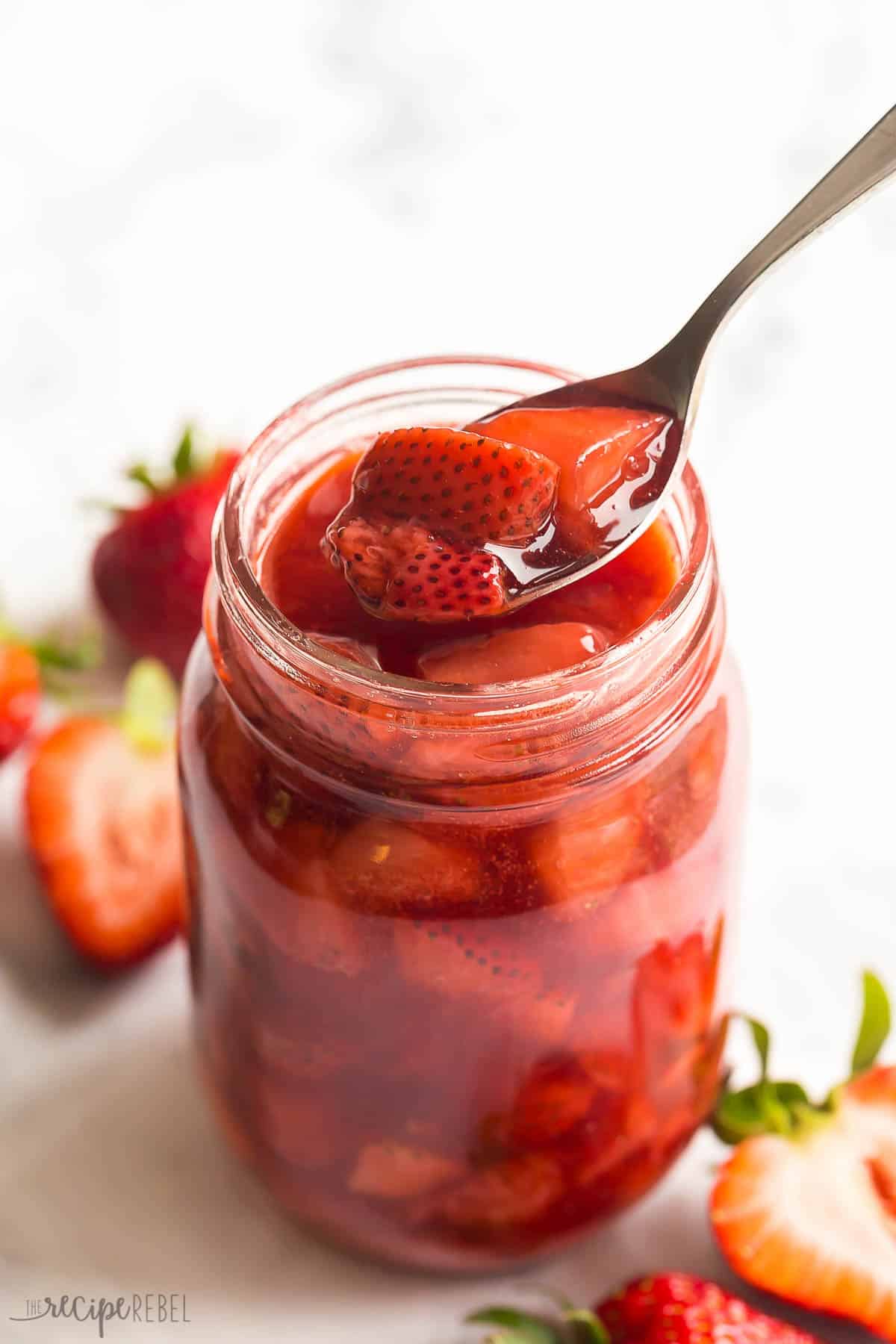 This easy Strawberry Sauce is made with fresh or frozen strawberries and perfect on waffles, pancakes, or ice cream! #strawberry #strawberries #dessert #recipe | strawberry recipes | strawberry desserts | easy dessert recipes | fresh strawberry sauce spoon scooping strawberry sauce out of jar.