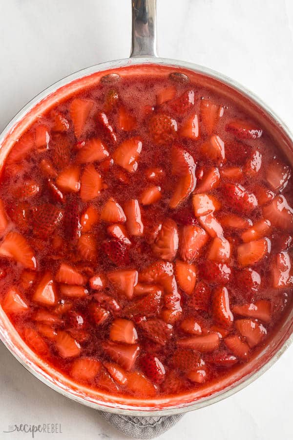 This easy Strawberry Sauce is made with fresh or frozen strawberries and perfect on waffles, pancakes, or ice cream! #strawberry #strawberries #dessert #recipe fresh strawberry sauce overhead in white pan