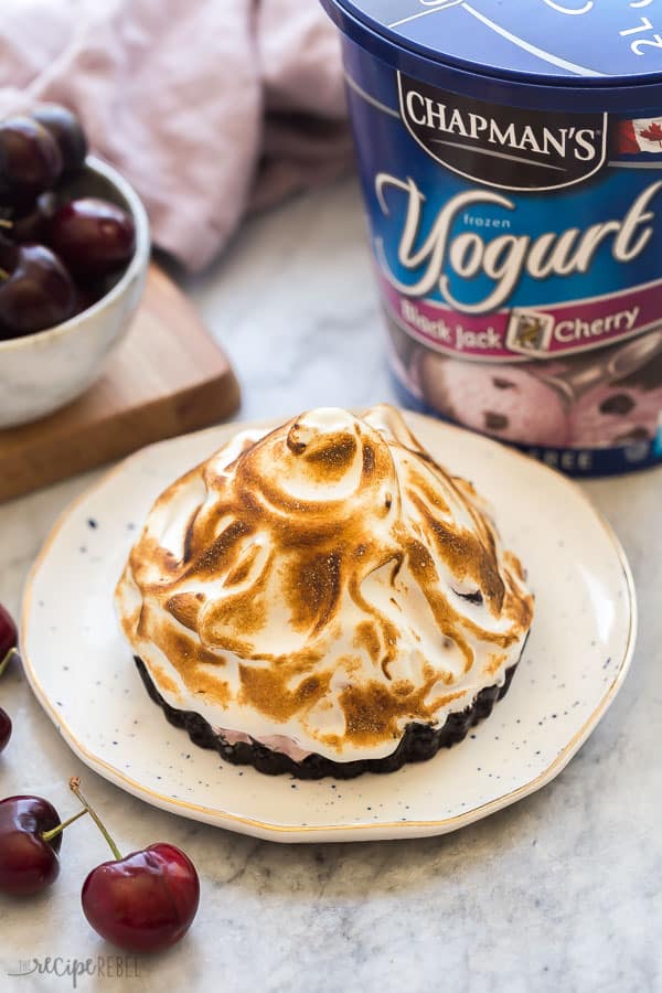 baked alaska tart on white plate in front of chapman's black jack cherry yogurt