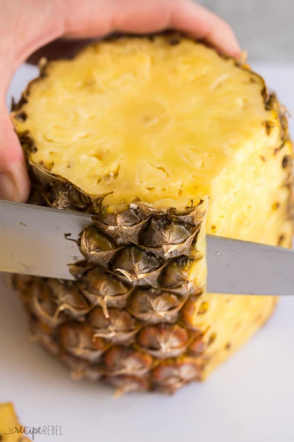 cut the sides off the pineapple with a sharp knife on a white cutting board