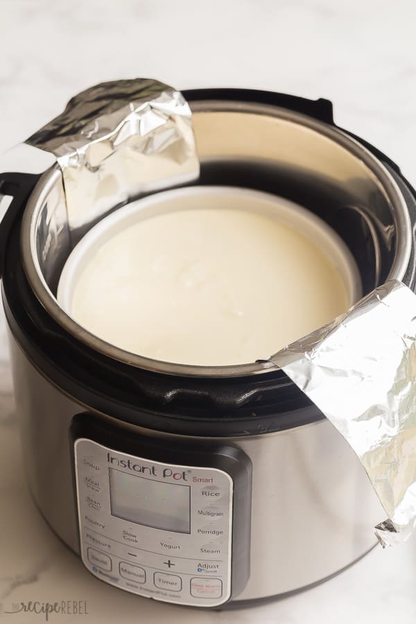 uncooked instant pot cheesecake in pressure cooker with tin foil sling under pan