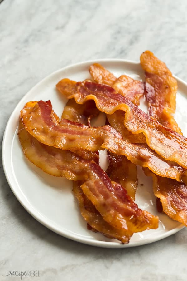 crispy oven bacon on white plate on grey marble background