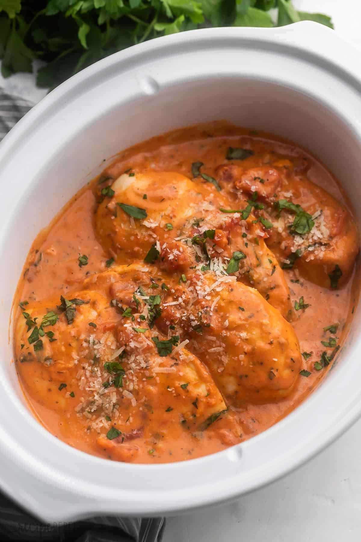 side angle of crockpot chicken breast in tomato basil sauce.