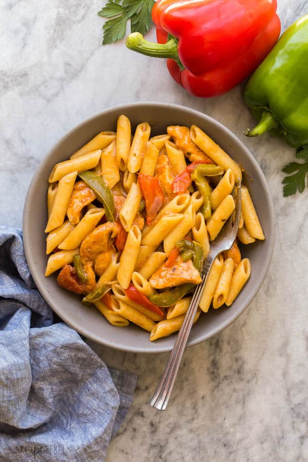 chicken fajita pasta in grey bowl on grey marble backgrouund