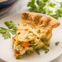 chicken pot pie slice on grey plate with fresh parsley