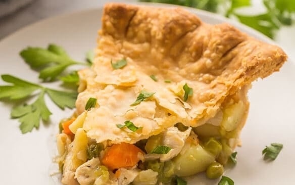 chicken pot pie slice on grey plate with fresh parsley