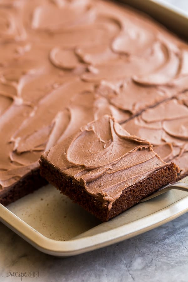 chocolate sheet cake piece being lifted out of pan