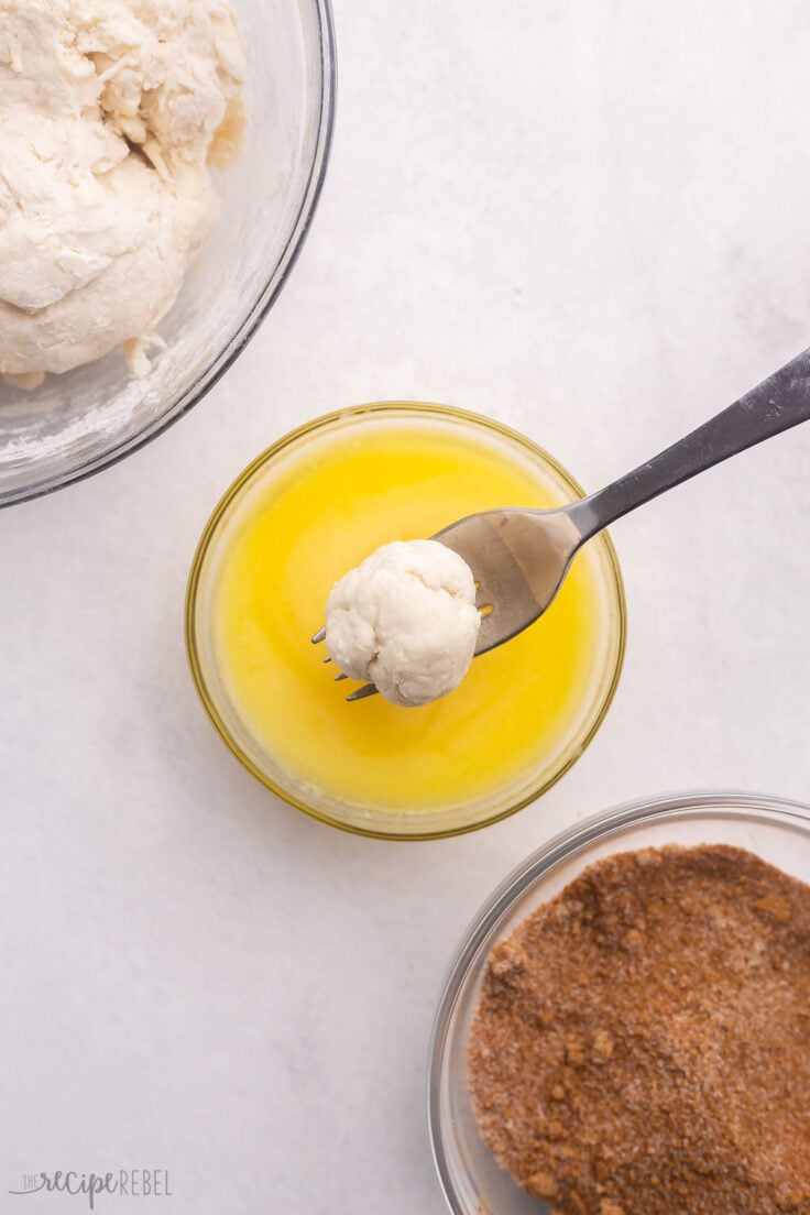 ball of biscuit dough being coated in butter.