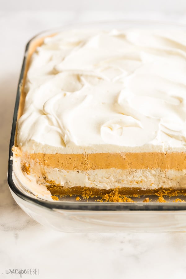 frozen pumpkin dessert with one row cut out in glass pan