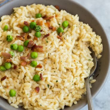 instant pot risotto in grey bowl with spoon on marble background