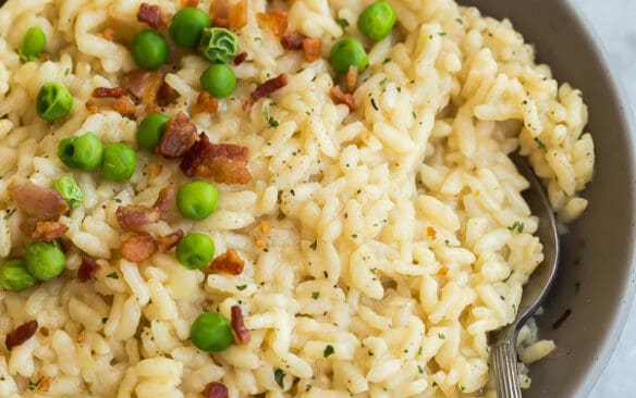 instant pot risotto in grey bowl with spoon on marble background