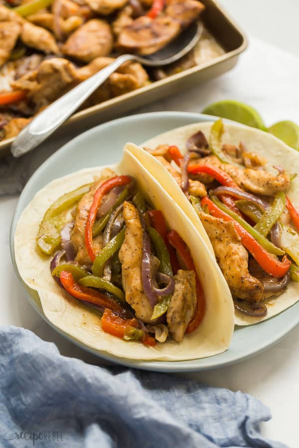 sheet pan chicken fajitas on two flour tortillas on plate