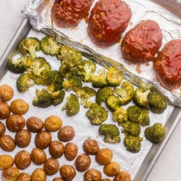 square image of mini meatloaf recipe with roasted broccoli and potatoes on a sheet pan.