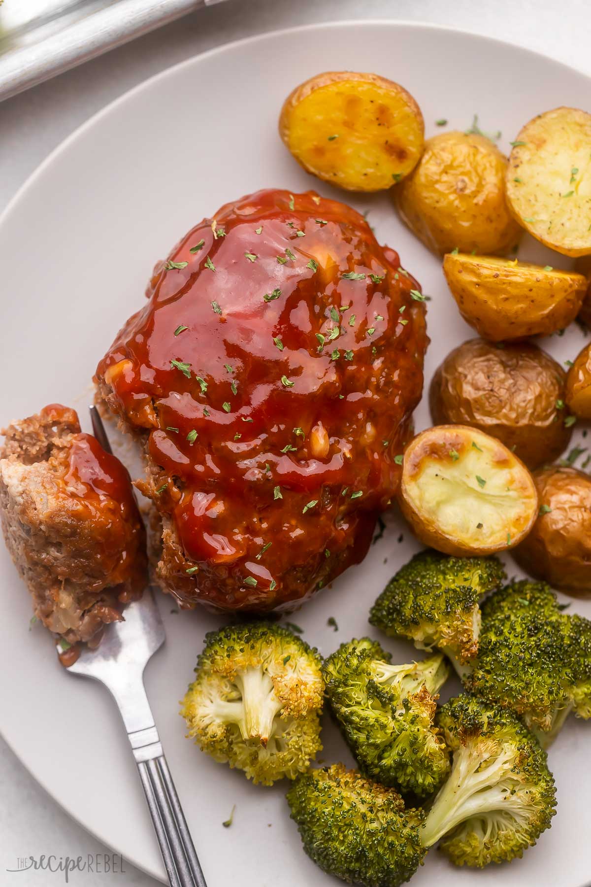 overhead image of a mini meatloaf on a plate with fork.