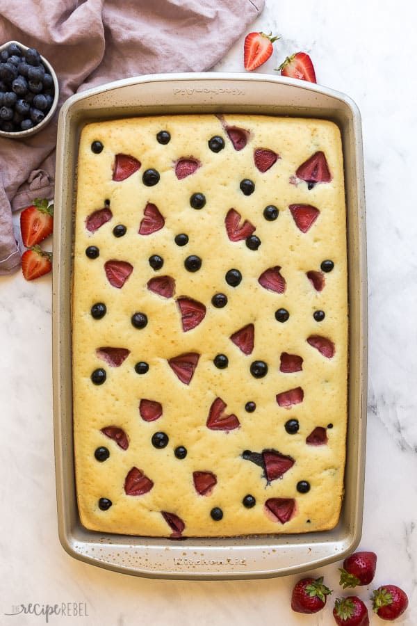sheet pan of pancakes overhead with strawberries and blueberries on top