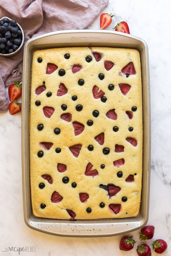This recipe for Sheet Pan Pancakes streamlines the pancake-making process so that you can enjoy homemade buttermilk pancakes any day of the week! #pancakes #breakfast #brunch #recipe #healthy sheet pan of pancakes overhead with strawberries and blueberries on top