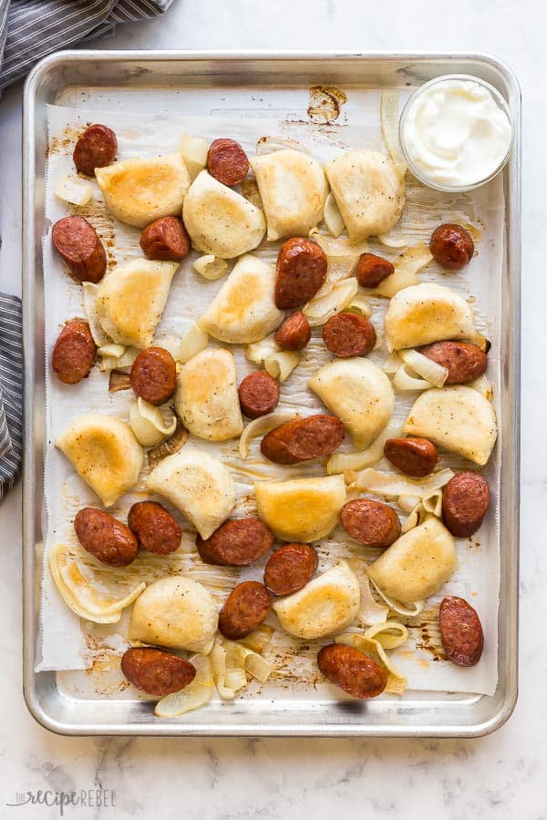 sheet pan sausage and perogies on parchment lined baking sheet