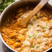 italian sausage gnocchi skillet with wooden spoon scooping