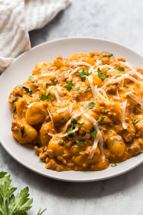 Gnocchi with italian sausage on grey plate topped with parsley