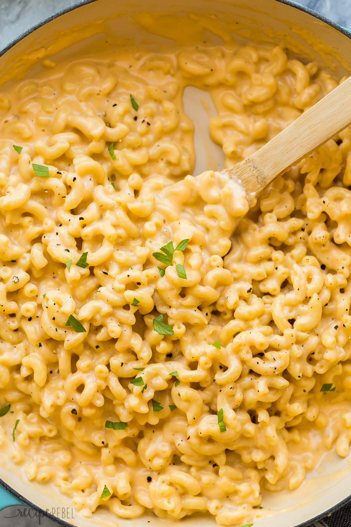 very close image of macaroni and cheese with wooden spoon