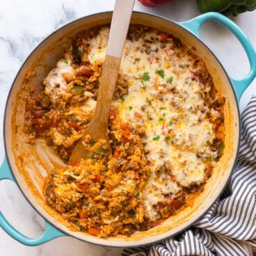 overhead image of stuffed pepper casserole with wooden spoon stuck in