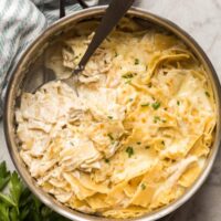 white chicken skillet in steel pan with spoon scooping some noodles