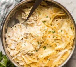 white chicken skillet in steel pan with spoon scooping some noodles