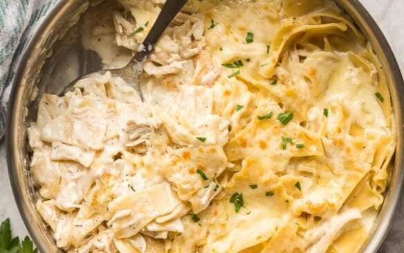 white chicken skillet in steel pan with spoon scooping some noodles