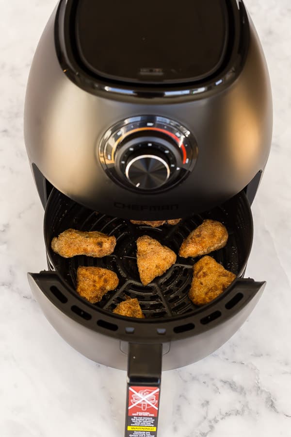 air fryer basket coming out to reveal crispy turkey nuggets