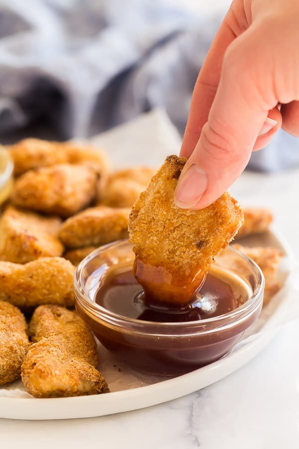 turkey nugget being dipped in sweet and sour sauce