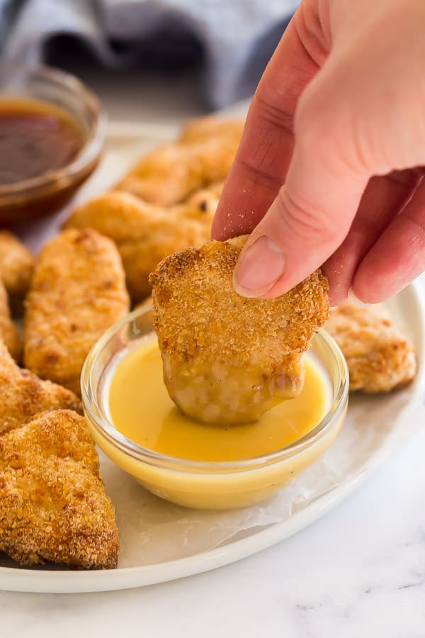 turkey nugget being dipped in honey mustard dipping sauce