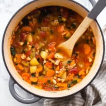 overhead image of pot of soup with wooden spoon stuck in