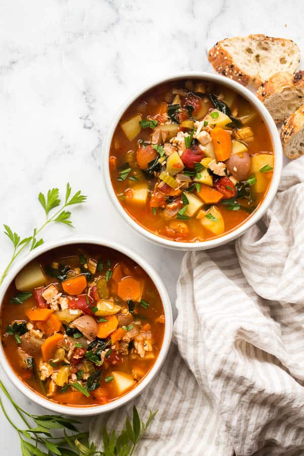 overhead image of two bowls of chicken vegetable soup