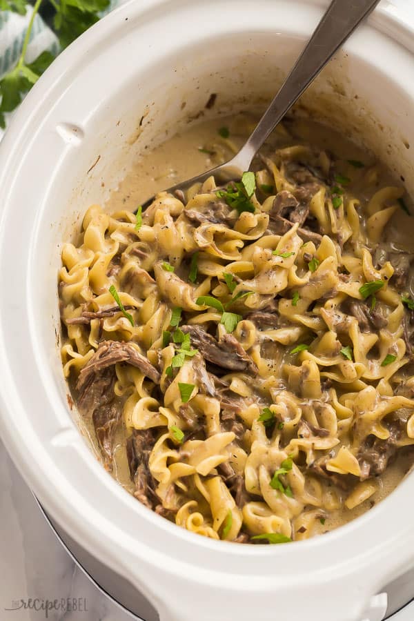 close up image of slow cooker with crockpot beef and noodles
