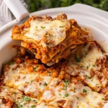 square image of piece of crockpot lasagna being removed from the slow cooker.
