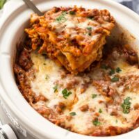 slice of lasagna being lifted out of crockpot