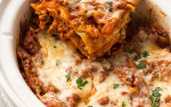 slice of lasagna being lifted out of crockpot