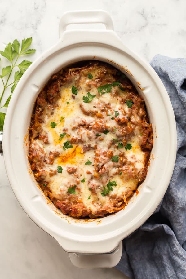 overhead image of crockpot lasagna in white slow cooker