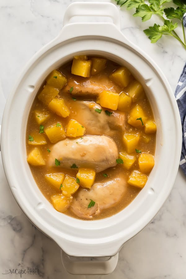 This Crockpot Pineapple Chicken is sweet and tangy and made with just SIX ingredients! You can prep ahead and freeze before cooking. Step by step video down in the recipe card. #crockpot #slowcooker #chicken #chickenbreast crockpot pineapple chicken breasts in slow cooker overhead