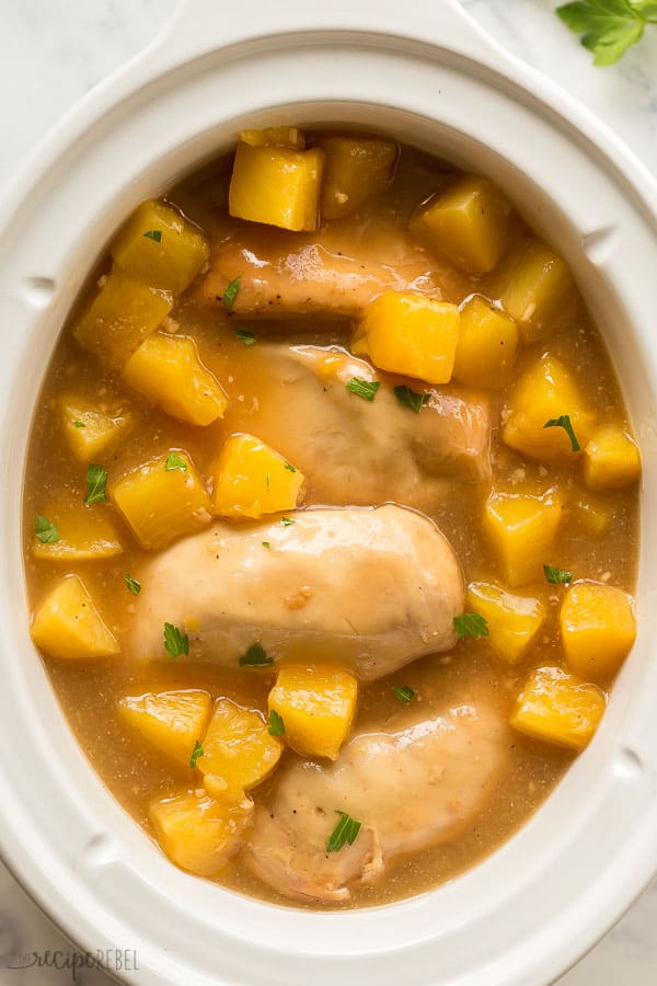 close up overhead image of pineapple chicken in slow cooker