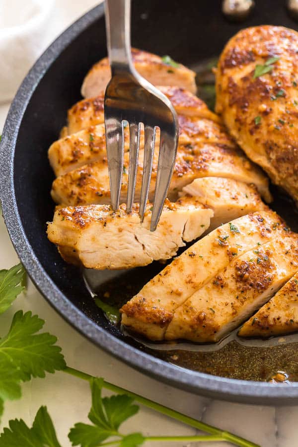 fork holding slice of pan fried chicken breast