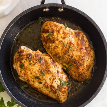 overhead image of pan fried chicken breasts in black ninja pan