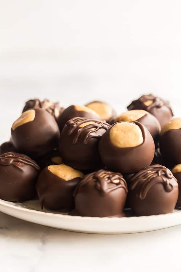 two layers of peanut butter balls stacked on white plate