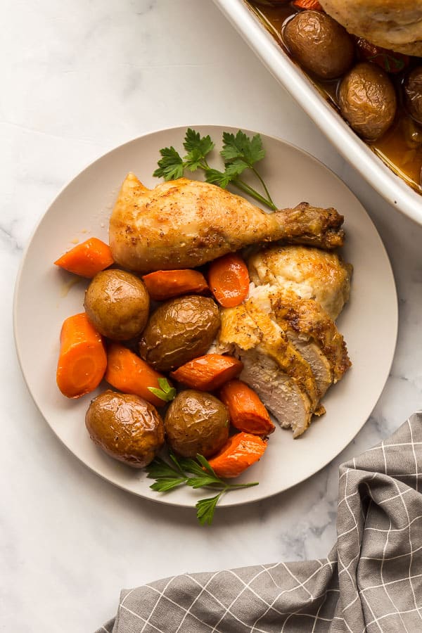 plate of chicken breast and drumstick with potatoes and carrots