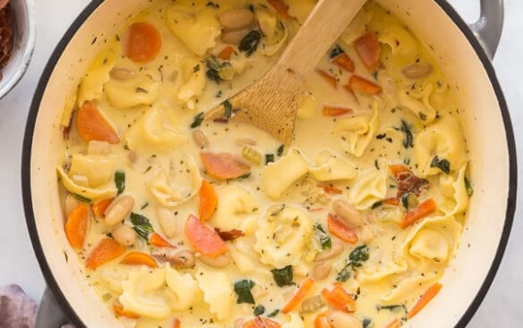 overhead image of spinach tortellini soup in grey dutch oven