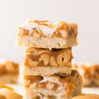 stack of three caramel nut bars on white background
