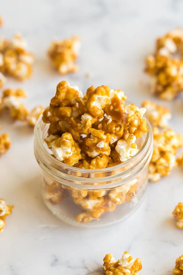 caramel popcorn in small jar with pieces around it