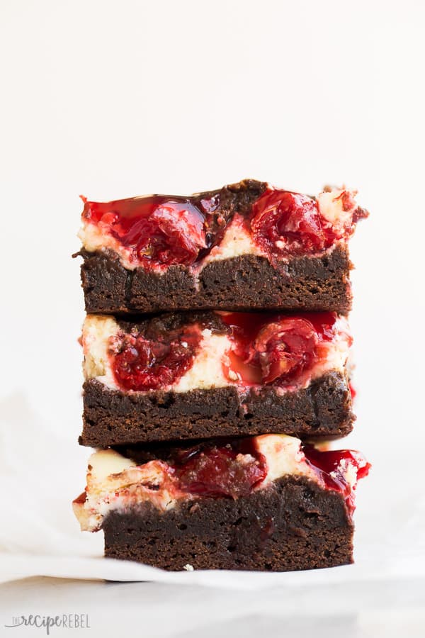 stack of three cherry cheesecake brownies on white background