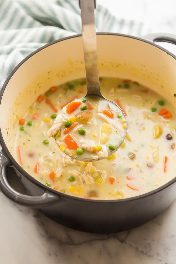 close up image of chicken pot pie soup on ladle