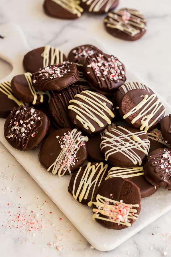 pile of chocolate dipped icebox cookies on marble cutting board